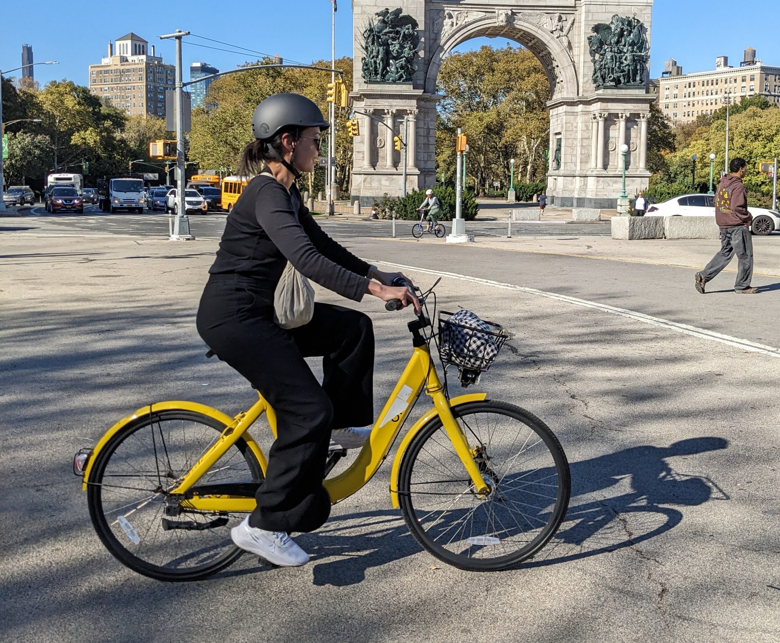 Adult rider with a yellow bicycle at Grand Army Plaza